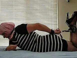 Daisy ist in einem eng anliegenden schwarz-weißen Kleid gefesselt.