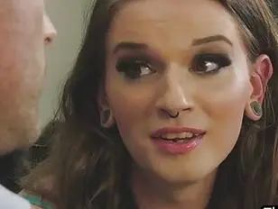 Sexy shemale Jenna Creed bends over the table to take a bigcock